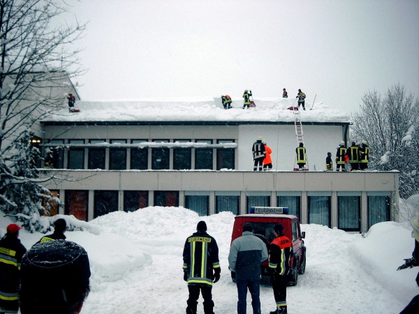Verschiedene Feuerwehren beim Schneeräumen eines Daches